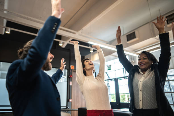 istock Coworkers celebrating with arms raised at office 1498006527