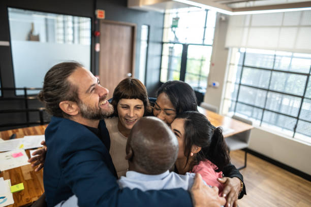 istock Coworkers embracing and celebrating at office 1498006530