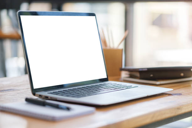 istock Laptop computer with white screen, notebook and pencil holder on wooden office desk. 1498006686