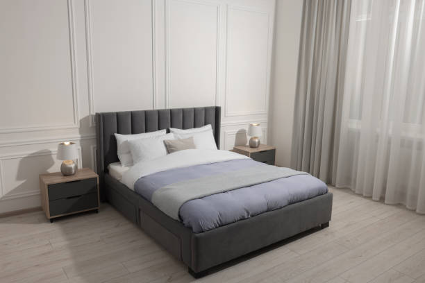 istock Comfortable bed between bedside tables with lamps at home. Interior design 1498009698
