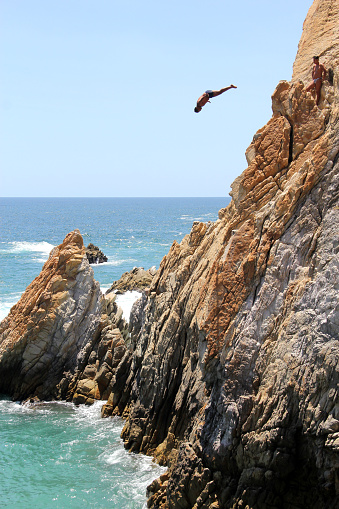 Acapulco, Guerrero, Mexico - Apr 28 2023: Divers of La Quebrada jump from a 45 meter cliff, they are the most popular attraction very old tradition