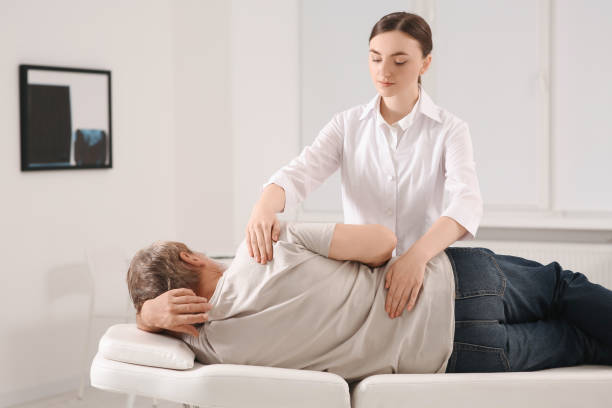 istock Professional orthopedist examining patient's back in clinic 1498014178