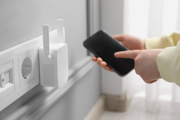 istock Woman using smartphone for wireless Wi-Fi repeater indoors, closeup 1498014262