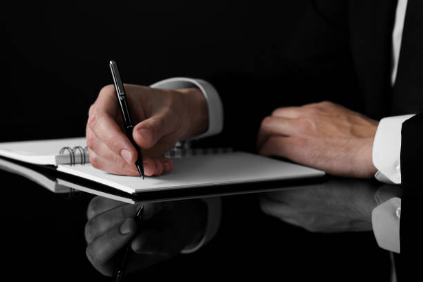 istock Man writing in notebook at black table, closeup 1498015303