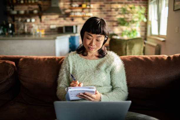 istock Young Japanese Woman using a laptop on a couch 1498022069