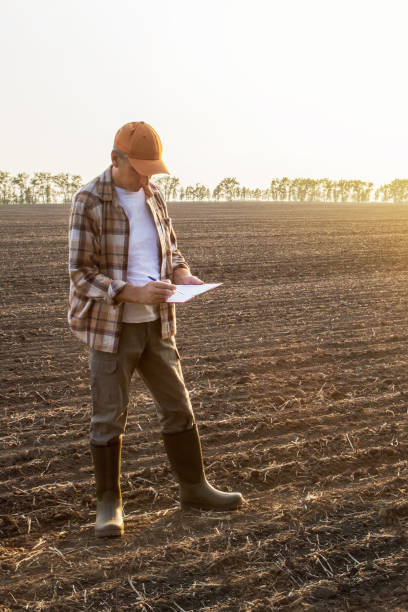 istock Farmer writting check list in a field. 1498027780