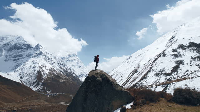 A man stands on top of a mountain in Nepal