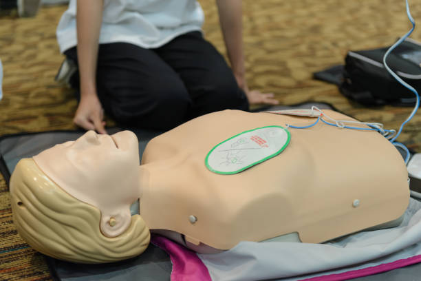 istock First aid cardiopulmonary resuscitation course using automated external defibrillator device - AED training. selective focus placing electrode. 1498035506