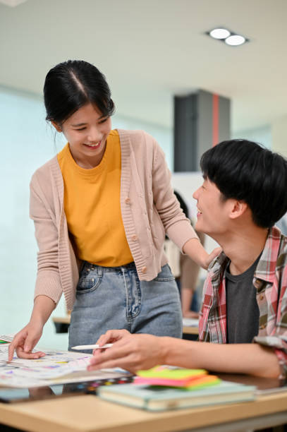 istock A friendly Asian female graphic designer is talking and working with a male developer 1498038886