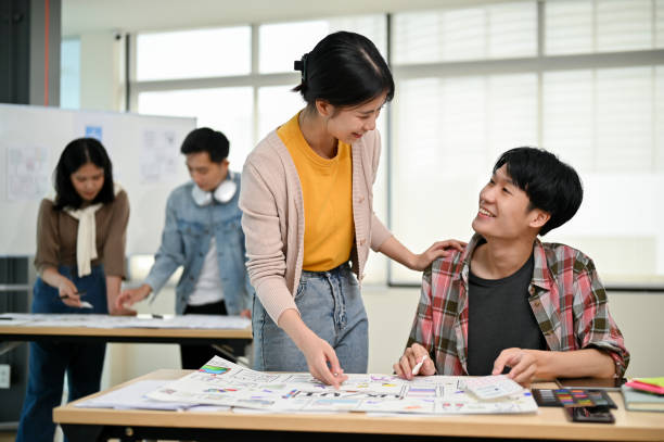 istock A female graphic designer is talking and working with a male developer in the office. 1498038892