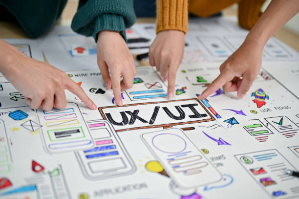 istock A close-up image of a developer's fingers pointing at UI and UX prototype paper on a table. 1498038901