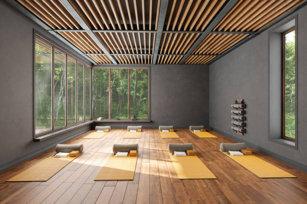 interior vacío del estudio de yoga con colchonetas de ejercicio, almohadas, bloques de yoga y vista al jardín desde la ventana - centro de yoga fotografías e imágenes de stock