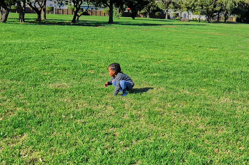 African black boy picking with flowers in a park.