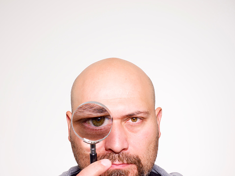 Bald head man Holding Magnifying