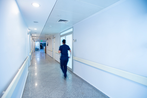 Blurred people walking in hospital corridor