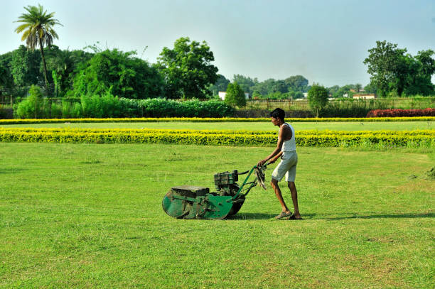 Gardener cutting grass of Khajuraho Temples garden state Madhya Pradesh