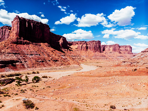 From an aerial perspective, Mineral Canyon near Dead Horse Point, Utah, presents a mesmerizing landscape of raw beauty. Stretching outside the boundaries of Canyonlands National Park and Moab, this rugged terrain showcases breathtaking vistas. The canyon's red and ochre cliffs, carved by the relentless force of time, stand as magnificent sentinels. Deep canyons intertwine, revealing intricate patterns as they wind through the desert floor. The Colorado River, a silver ribbon, weaves through the labyrinth of stone, adding a touch of serenity to the scene. This bird's-eye view unveils nature's masterpiece, a testament to the grandeur of the Southwest's geological wonders.