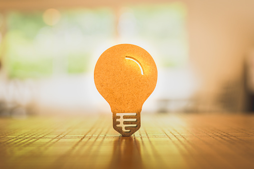 Light bulb symbol on wood table. Alternative energy, idea, saving electricity innovation and inspiration concepts.