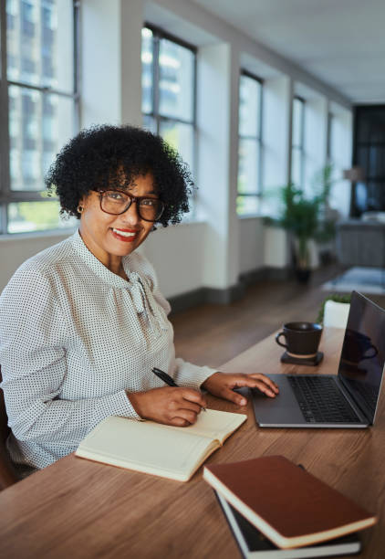 istock A happy and mature business woman  writing down notes while scrolling on her laptop computer with copy space. Stock photo 1498066012