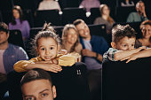 Small kids watching a movie in cinema.