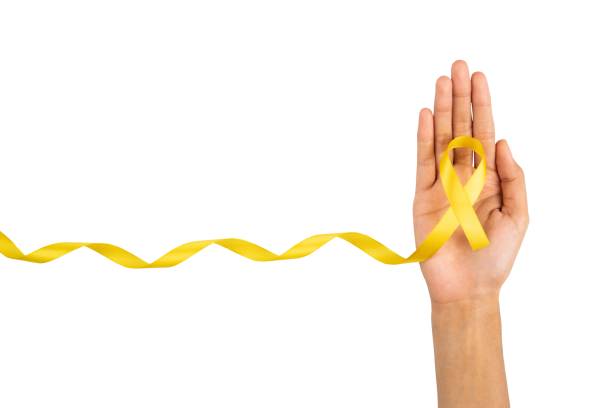 Hand holding yellow ribbon symbol isolated