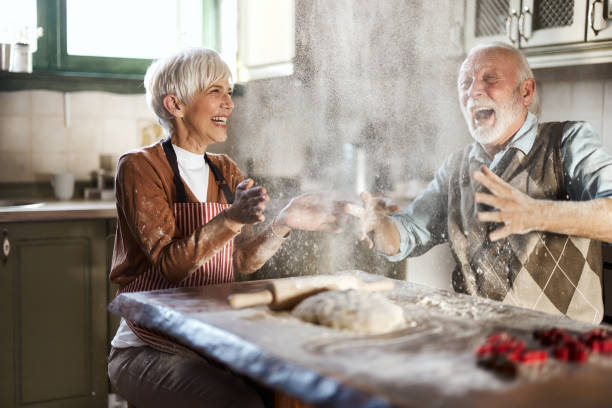 istock Cheerful mature couple having fun while making a cake in the kitchen. 1498069059