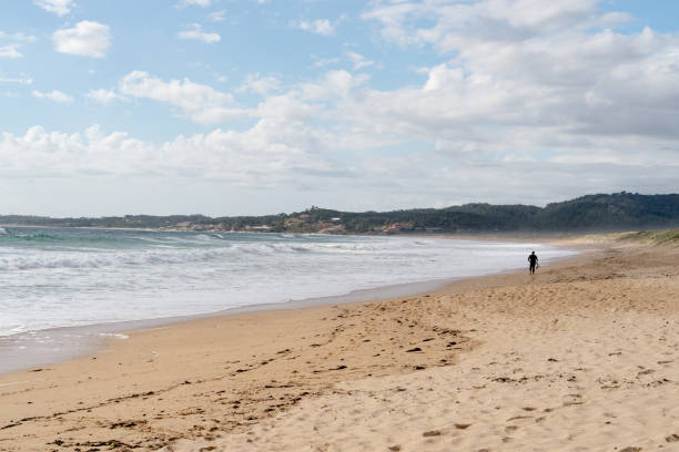 istock Man walking on a sandy beach in Lanzada beach, Galicia, Spain. 1498071867