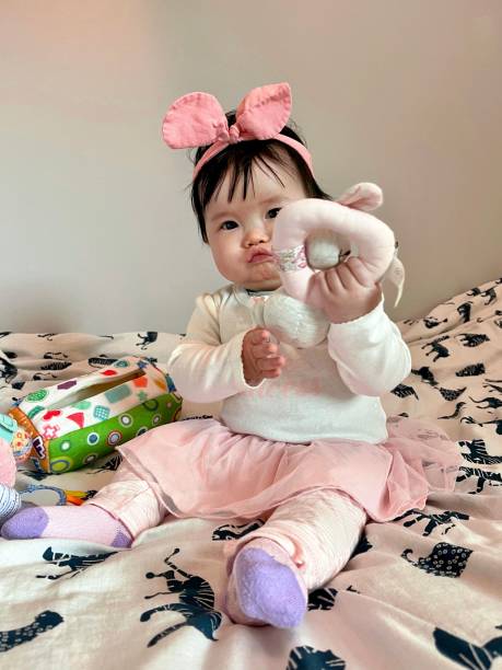 istock Asian little girl sitting on bed 1498072124