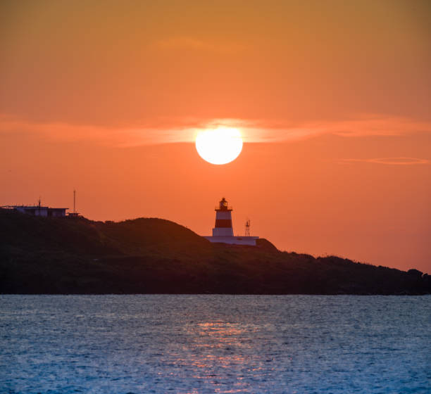 istock At dusk, the sun is above the lighthouse. 1498073850