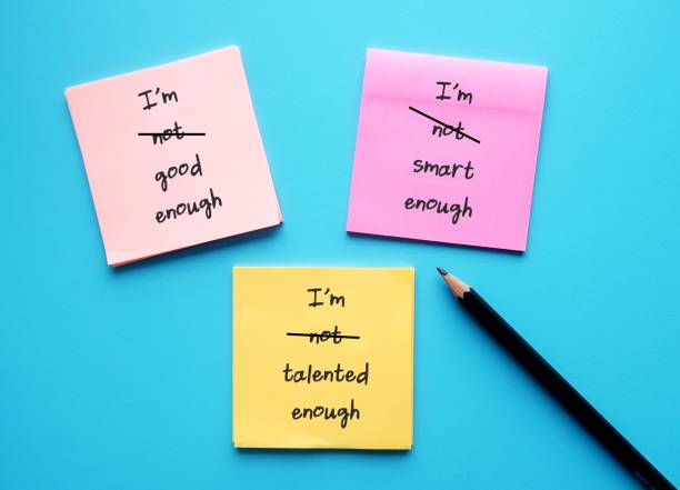 istock Three paper note with handwritten text I AM NOT GOOD ENOUGH, NOT SMART ENOUGH, NOT TATLENTED ENOUGH - crossed off NOT to overcome self criticism, boost self esteem, validation and acceptance 1498073976