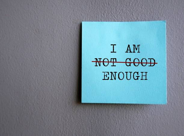 istock Blue note on gray wall with text I AM NOT GOOD ENOUGH with red crossing on NOT GOOD , concept of self worth , stop striving for approval, more valid , more loved or validation , you are good enough 1498074015