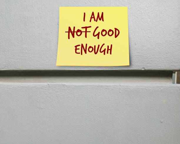 istock Yellow note stick on copy space wall I AM NOT GOOD ENOUGH (cross out NOT) , means building self-esteem , love and respect yourself unconditionally, never underestimate or seeking others approval, stop comparing  to other people and embrace flaws or imperf 1498074835