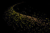A large number of gold particles converged on the black background