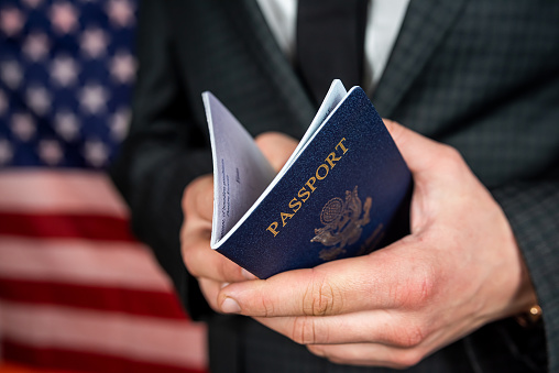 business man holding and reading USA passport. Business travel concept