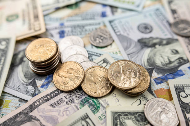 istock background of ste different us dollar paper money and coin cent 1498076492