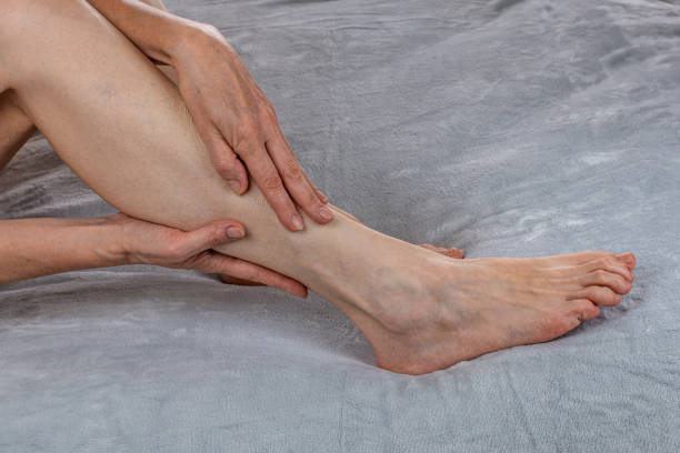 A woman is massaging her legs. Women's feet health care. Spa treatments at home. Close-up of female hands doing reflexology of their legs. Revitalizing foot massage. The concept of female body care. una mujer está masajeando sus piernas. cuidado de la salud de los pies de la mujer. tratamientos de spa a domicilio. primer plano de manos femeninas haciendo reflexología de sus piernas. masaje revitalizante de pies. el concepto de cuidado del cuerpo fem