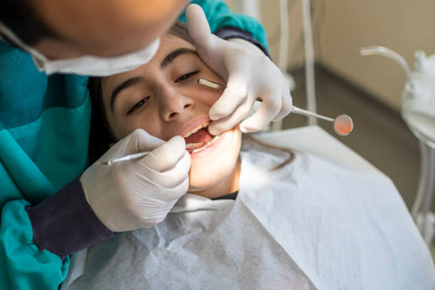 Dentists with a patient during a dental intervention to girl stock photo