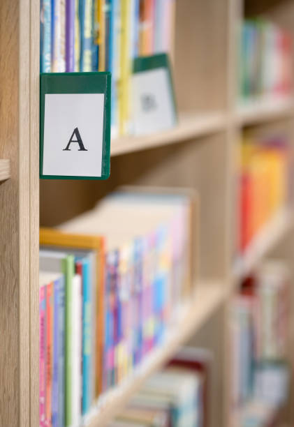 istock Book shelves with books and catalogue letter in library 1498080222