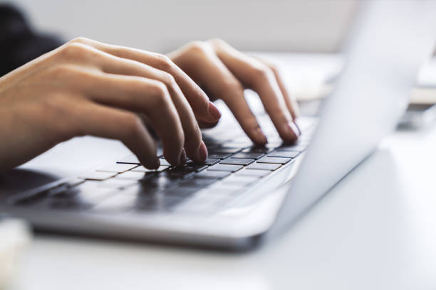 istock Woman's fingers nimbly typing on a cutting-edge laptop keyboard, with a blurred office scene behind 1498082637