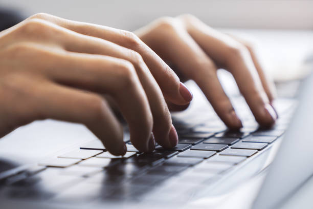 Woman's fingers nimbly typing on a cutting-edge laptop keyboard, with a blurred office scene behind Woman's fingers nimbly typing on a cutting-edge laptop keyboard, with a blurred office scene behind nimbly stock pictures, royalty-free photos & images