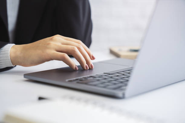istock The image details a woman's hands typing on an advanced laptop keyboard, with the office surroundings blurred in the background 1498082673