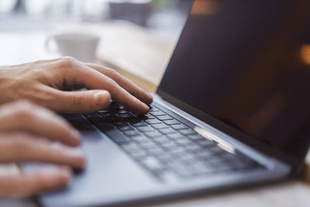 istock Against a fuzzy office backdrop, a close-up captures a man's hands deftly navigating a modern laptop's keyboard. 1498082870