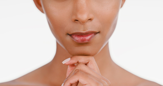 Closeup, lips and woman with skincare, glow and dermatology isolated against a white studio background. Zoom, female and person with cosmetics, mouth and grooming with beauty, wellness and shine