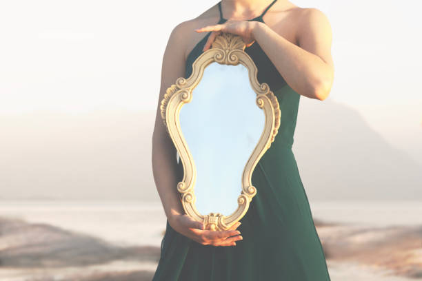 istock woman holding a magical mirror which reflects sunlight; abstract concept 1498085557