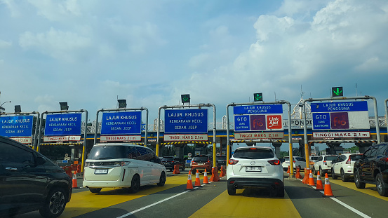 A landscape photo of blue toll booth gates (GTO) for minibus, jeep, and sedan cars (max 2.1 m) before entering and paying toll fee with e-toll or e-money card. This photo was taken at Pondok Ranji toll booth, Tangerang.
