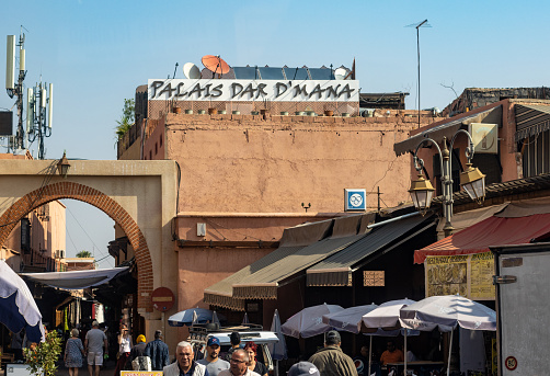 People walking near Palais Dar D'Mana on Rue Riad Zitoun el Kdim in Marrakesh, Morocco. This is a commercial restaurant in the Mellah (Jewish District).