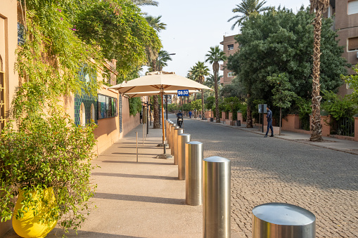 Tourists walking in the distance on the Rue Yves St Laurent in Marrakesh at Marrakesh-Safi, Morocco, outside the Majorelle Gardens.