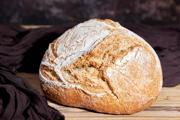 istock Golden loaf of bread on a table 1498091328