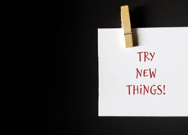 istock Note stick on copy space background with text written TRY NEW THINGS , concept of discover new interests and hobbies, get out of your comfort zone and try new things 1498092198