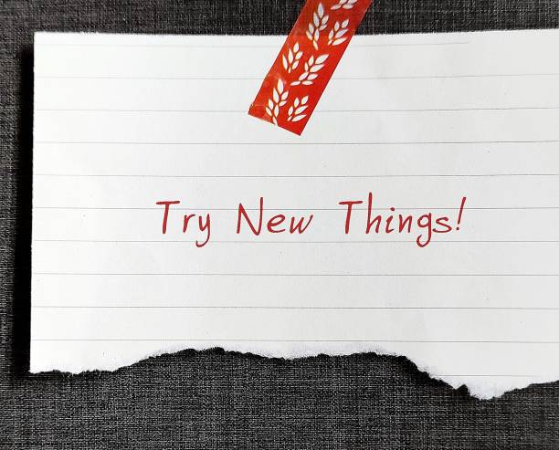 istock Note stick on wallpaper background with text written TRY NEW THINGS , concept of discover new interests and hobbies, get out of your comfort zone and try something new 1498092211